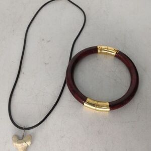 Dark wooden bangle bracelet trimmed in gold, and a‎ bone sharks tooth necklace